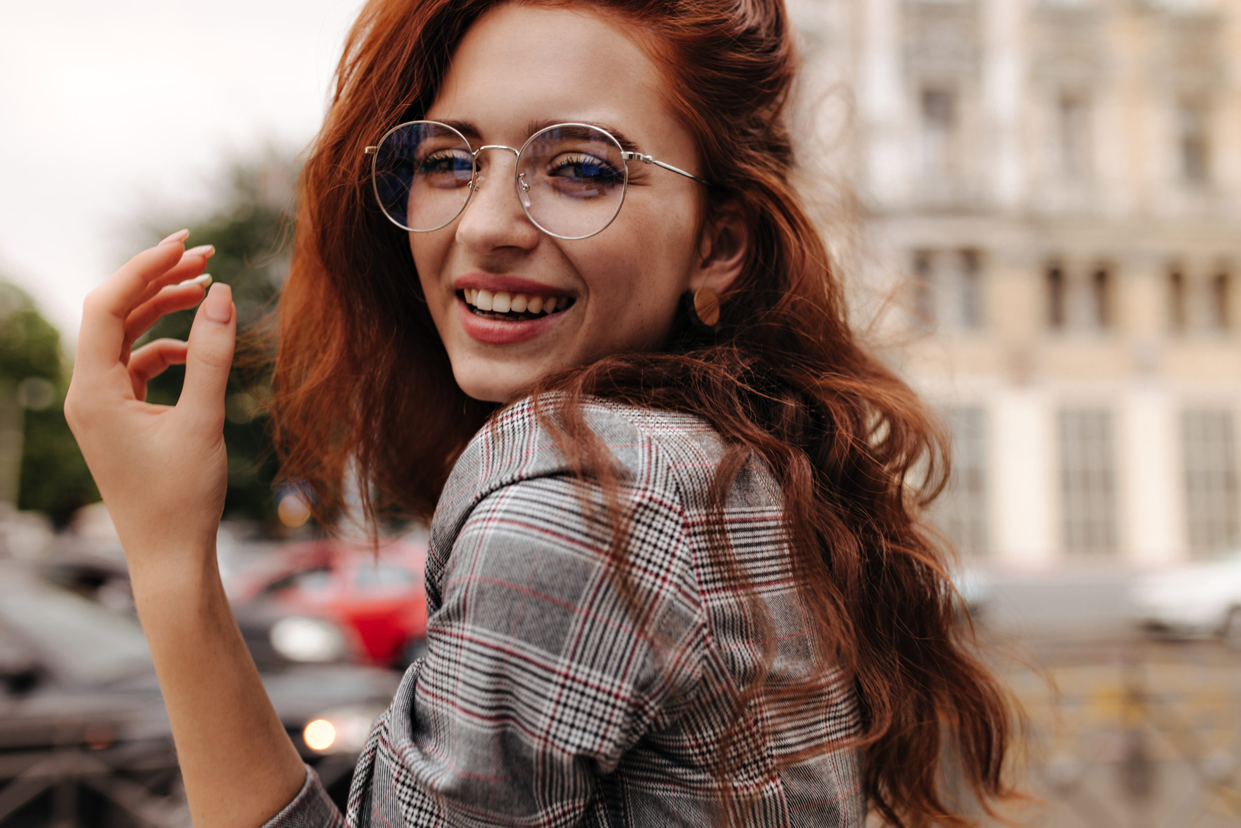 Woman in plaid with glasses smiling at camera